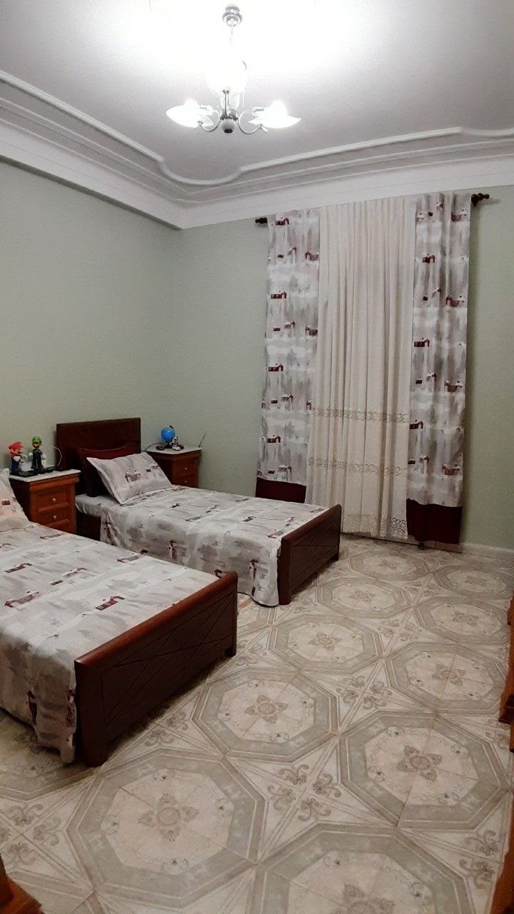Shared wooden bed room with layered curtains