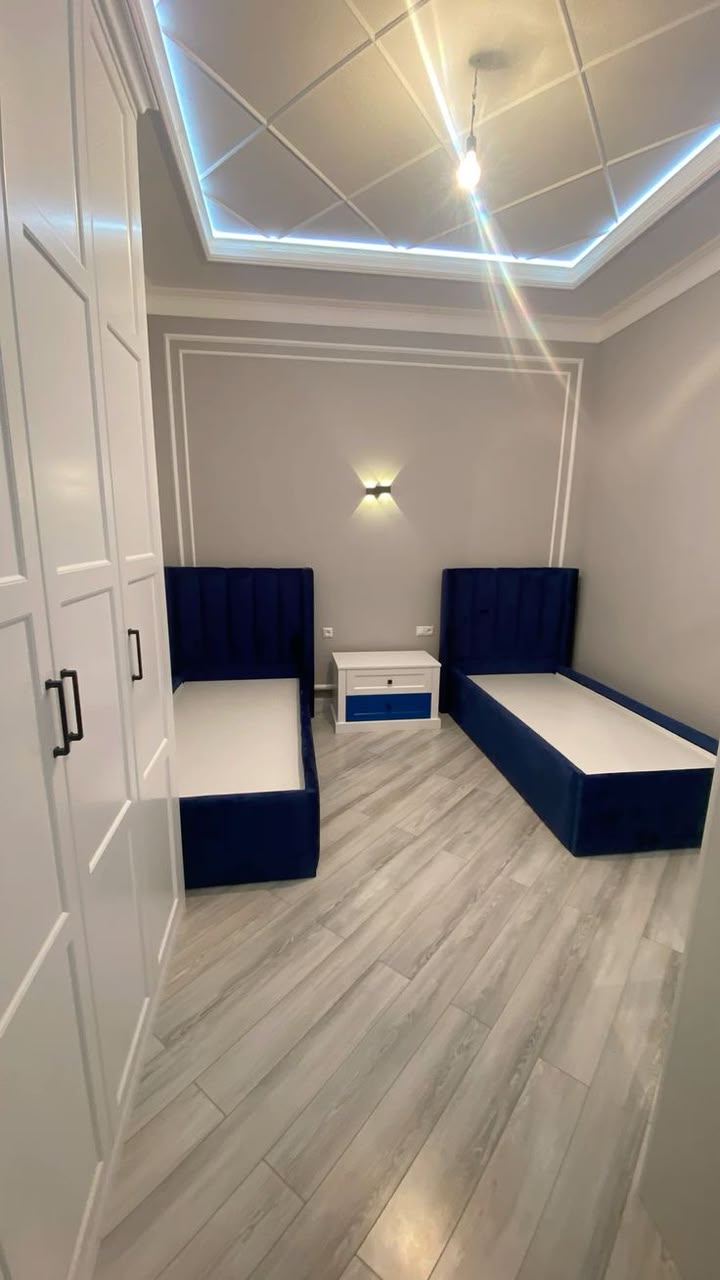 Shared room with navy blue beds and modern ceiling