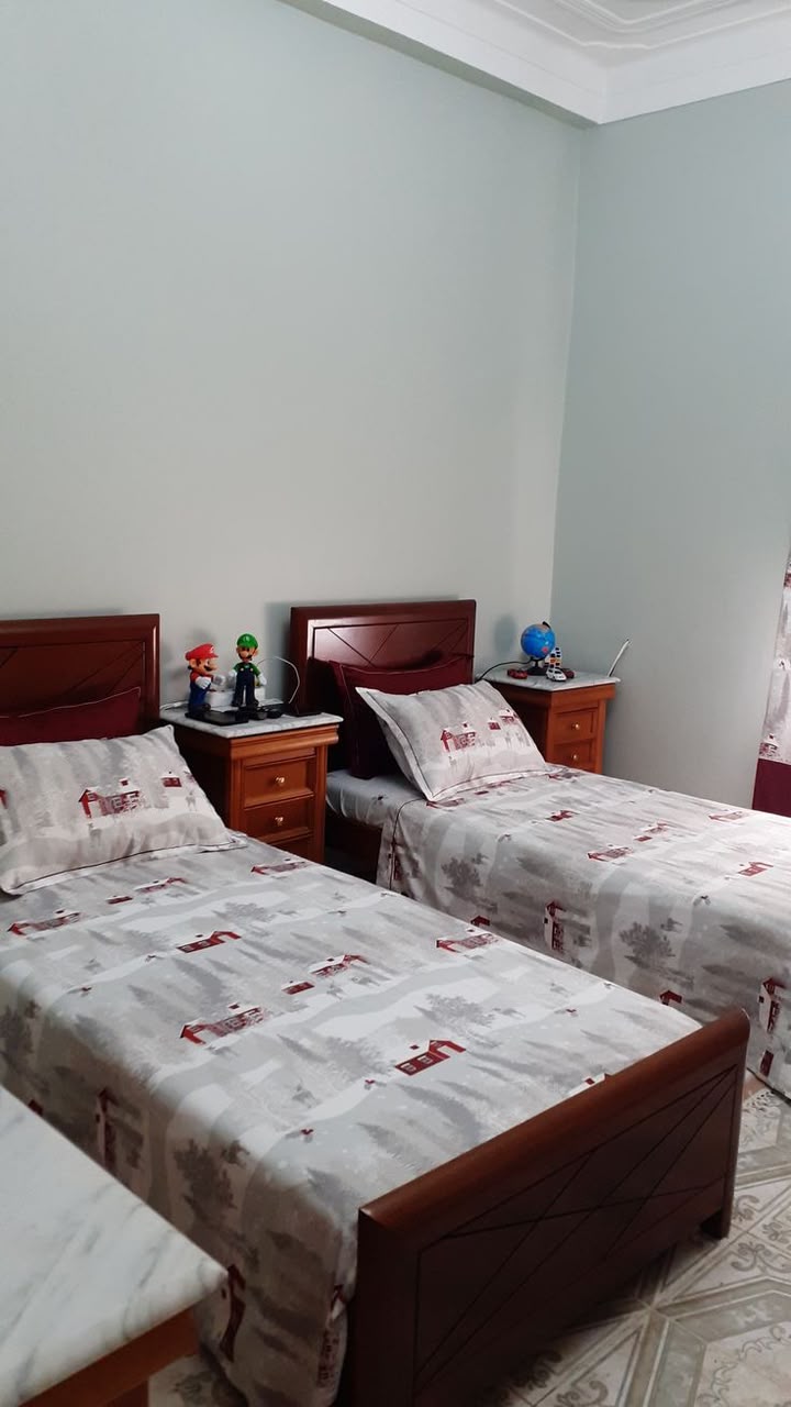 Shared wooden bed room with marble side tables